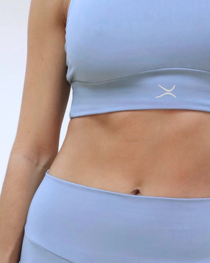 Detalle del top deportivo de ELIX Pilates con el logo sobre el abdomen